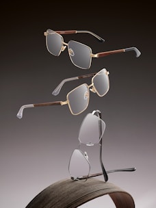 Three pairs of modern eyeglasses on a dark background.