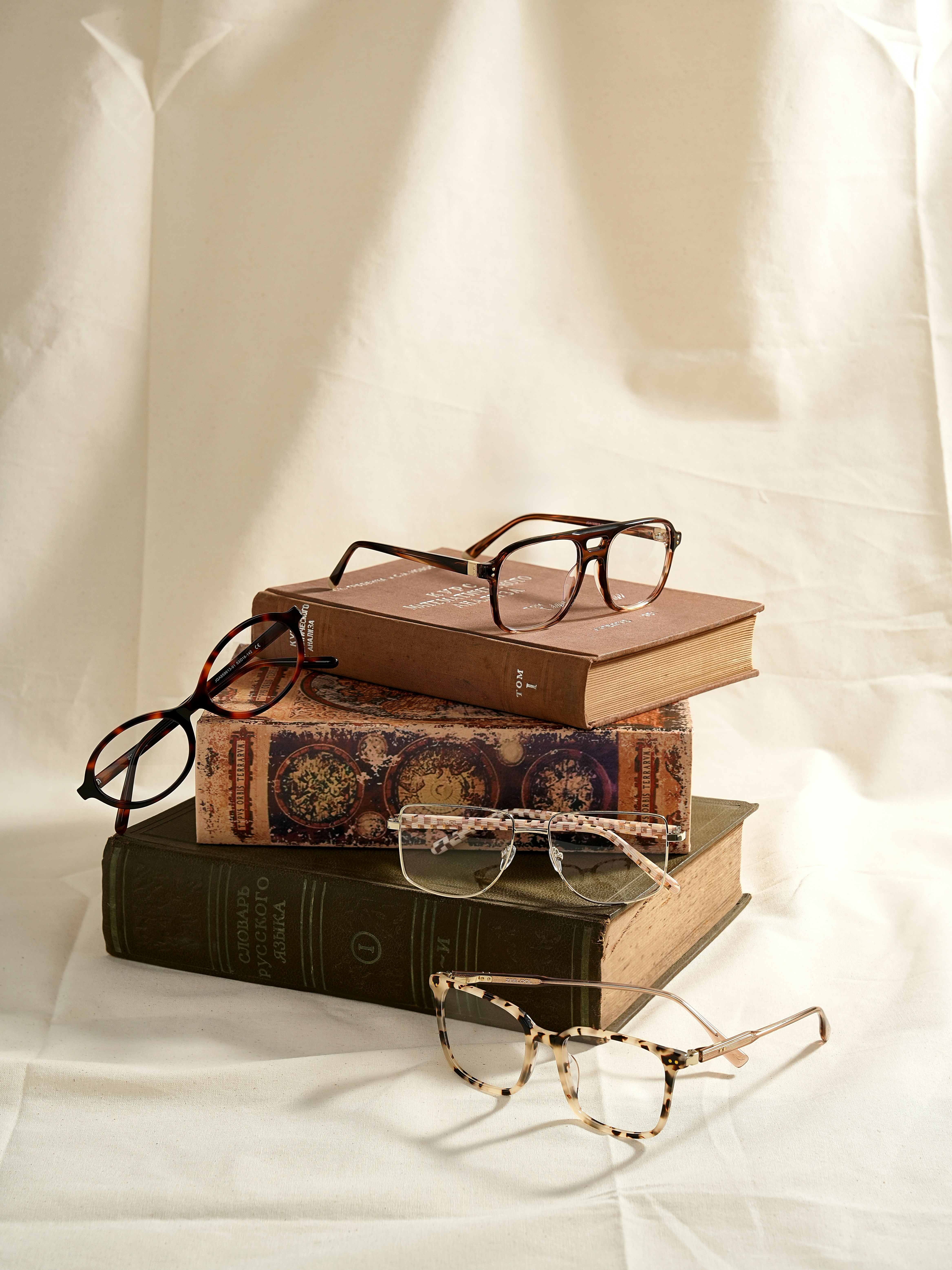 Several pairs of glasses resting on books
