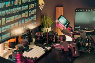 Desk with cameras, lenses, and computer screen.