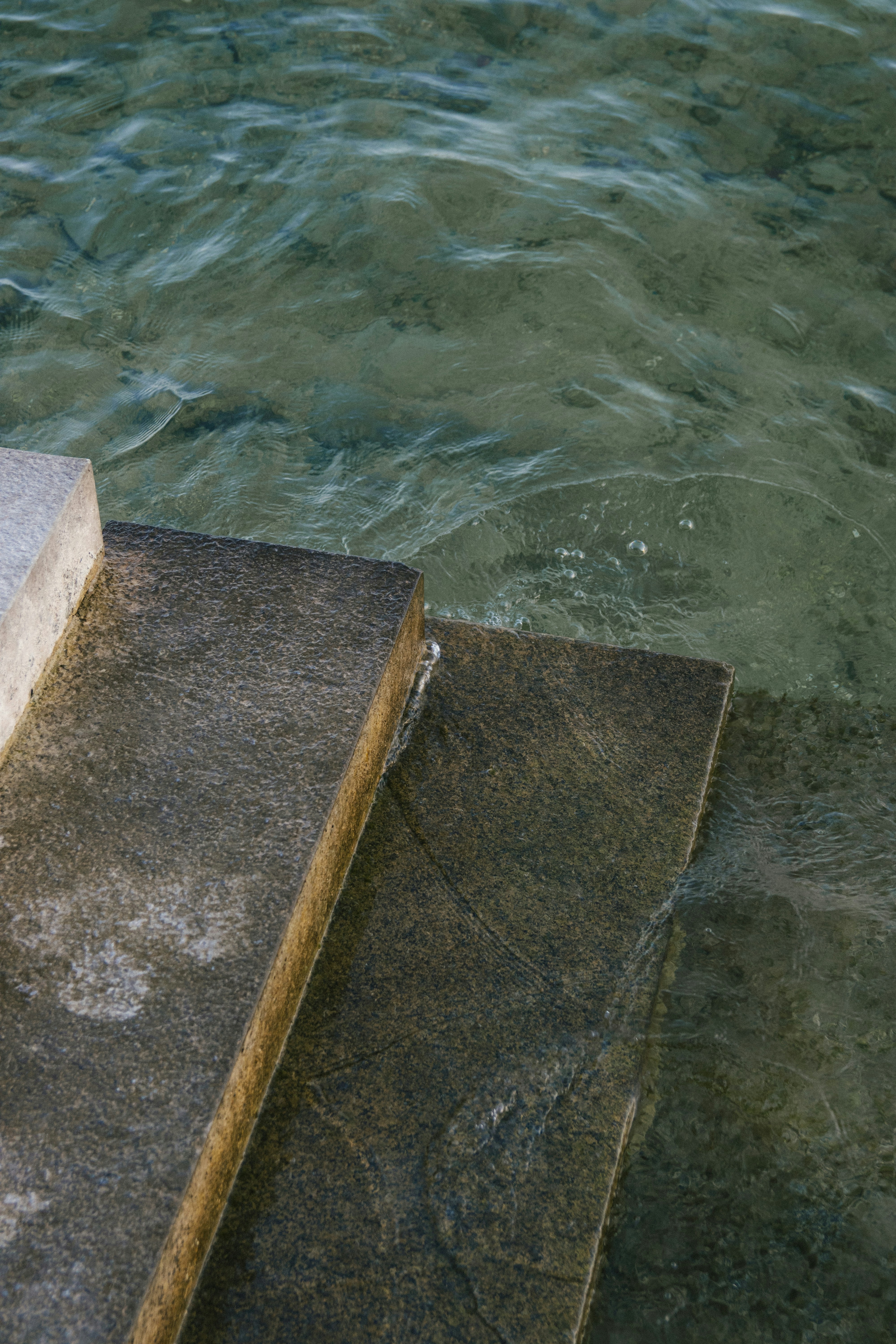 Steinstufen, die in klares Wasser führen