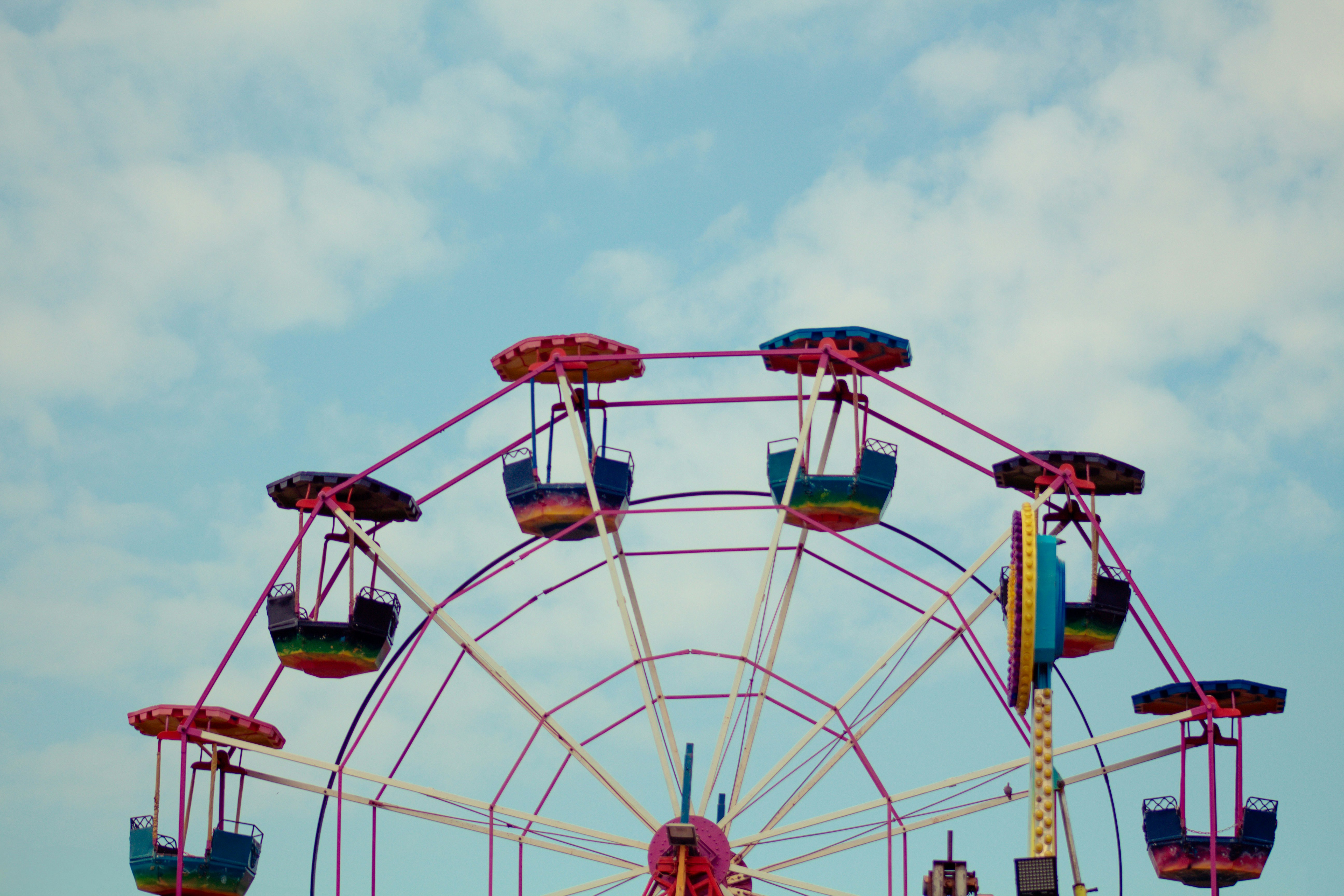 Ferris wheel with colorful gondolas against a blue sky.
