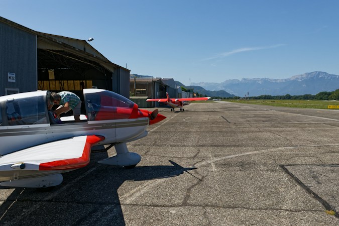 Small private airplanes parked on a sunny airfield with mountains in the background, similar to the general aviation planes that use North Las Vegas Airport