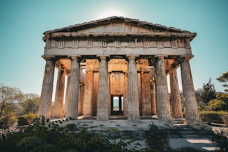 Ancient greek temple with large columns under blue sky.