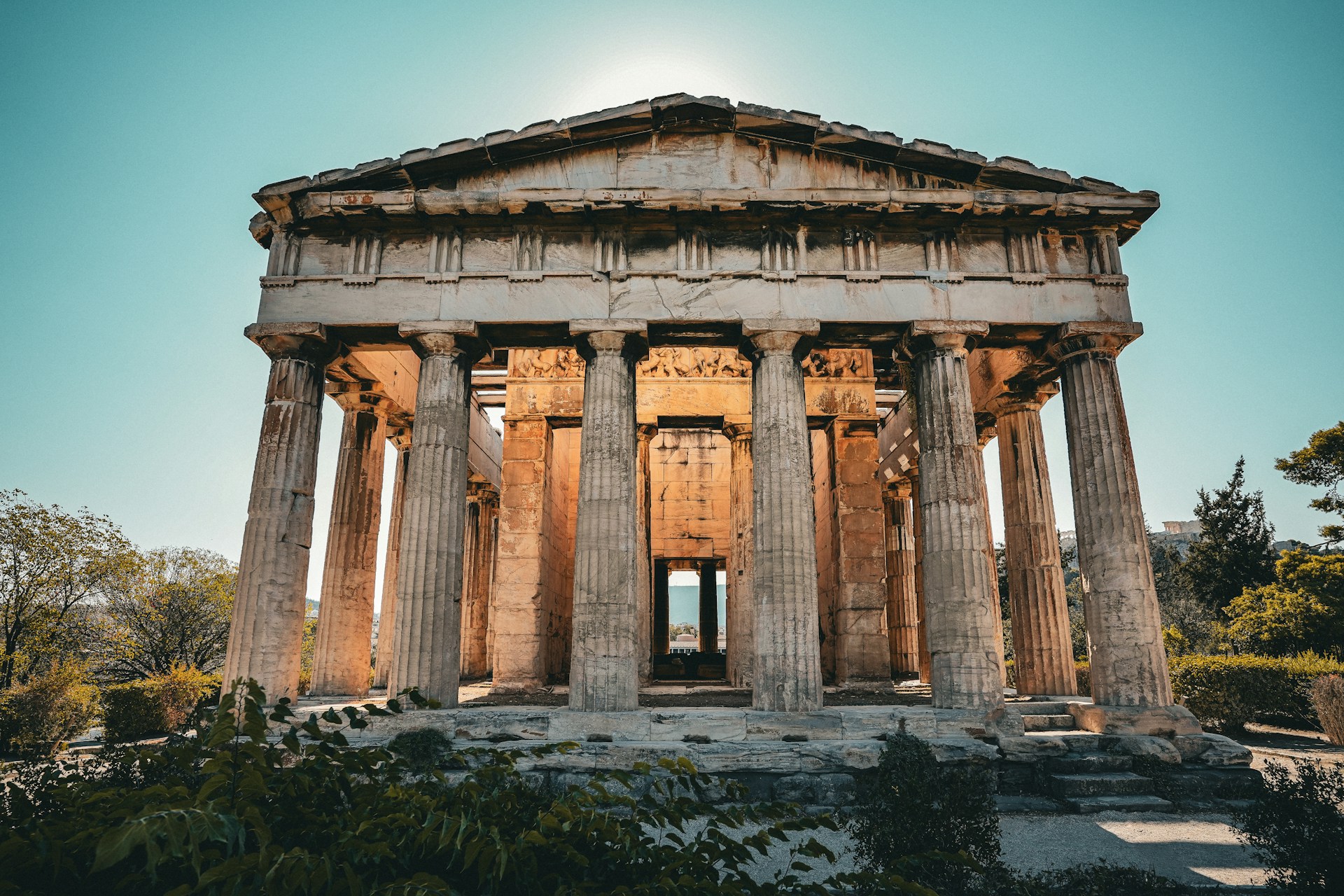 Ancient greek temple with large columns under blue sky.