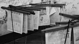 Newspapers hanging on wooden racks to dry.