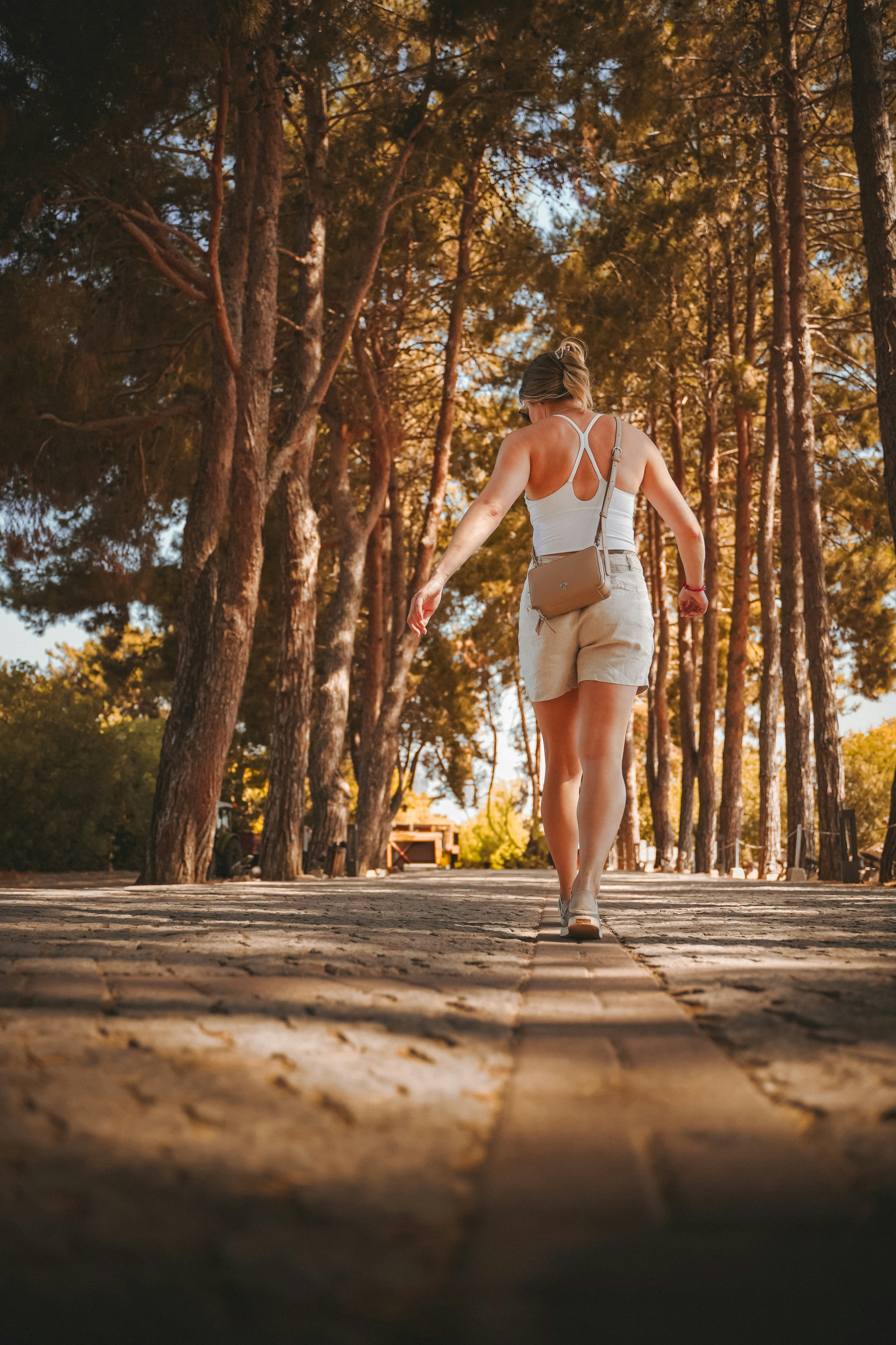Woman walking on a path through autumn trees