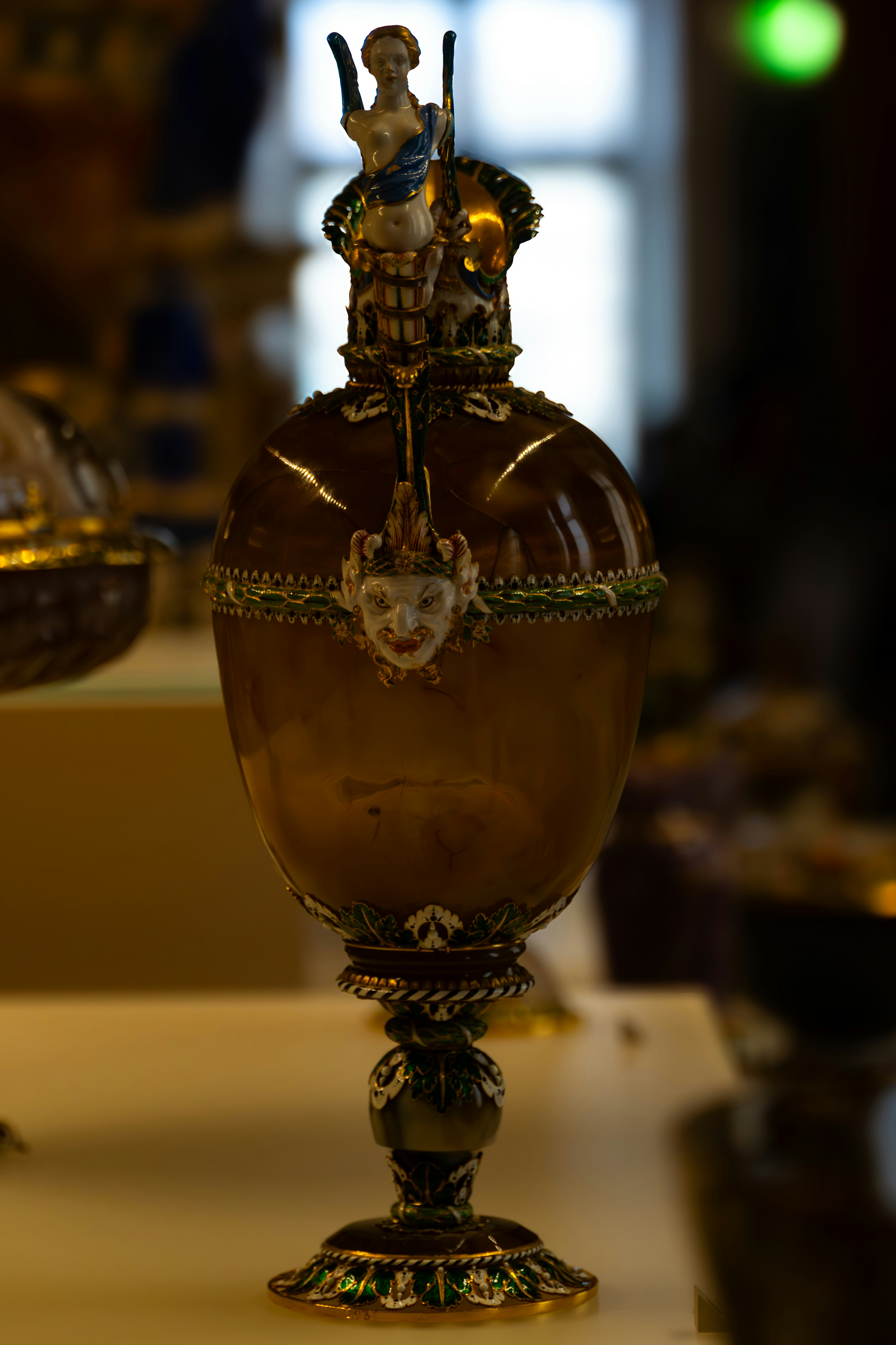 Ornate goblet with detailed figures and amber-face embellishments.