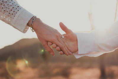 Couple holding hands with engagement ring