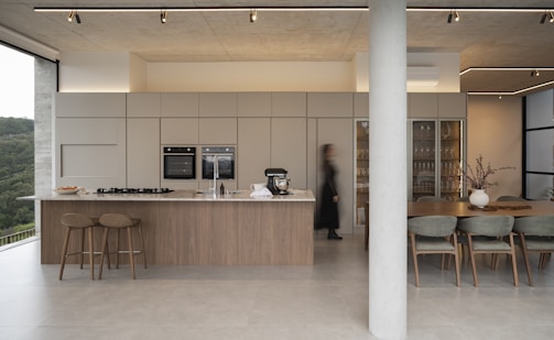 Modern kitchen and dining area with large windows.