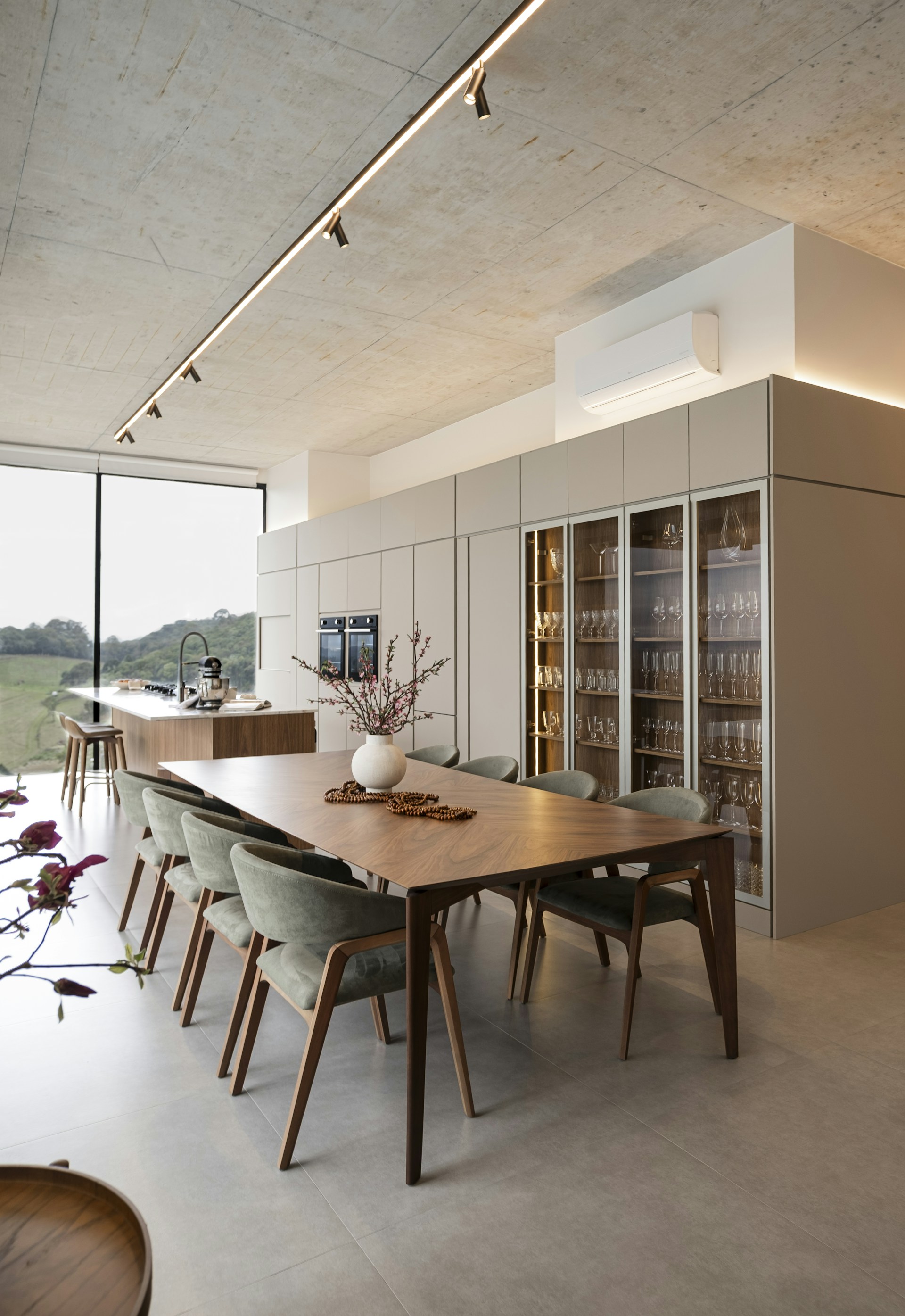 Modern dining room with large table and wine cabinet.
