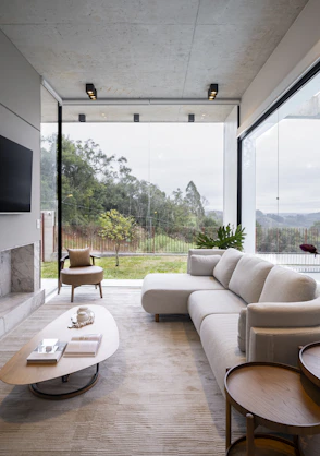 Modern living room with large windows overlooking nature