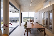 Modern dining room with expansive windows and scenic view.