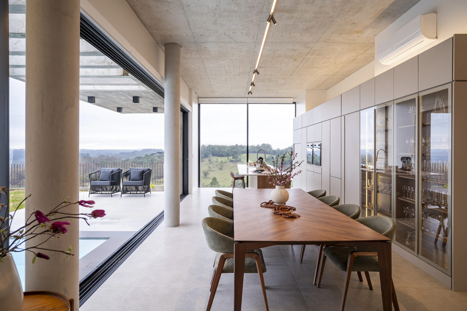 Modern dining room with expansive windows and scenic view.
