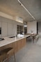 Modern kitchen island with dining area and concrete ceiling.