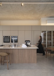 Modern kitchen with island and woman walking