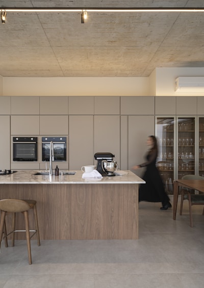 Modern kitchen with island and woman walking