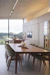 Modern dining room with large window and scenic view.