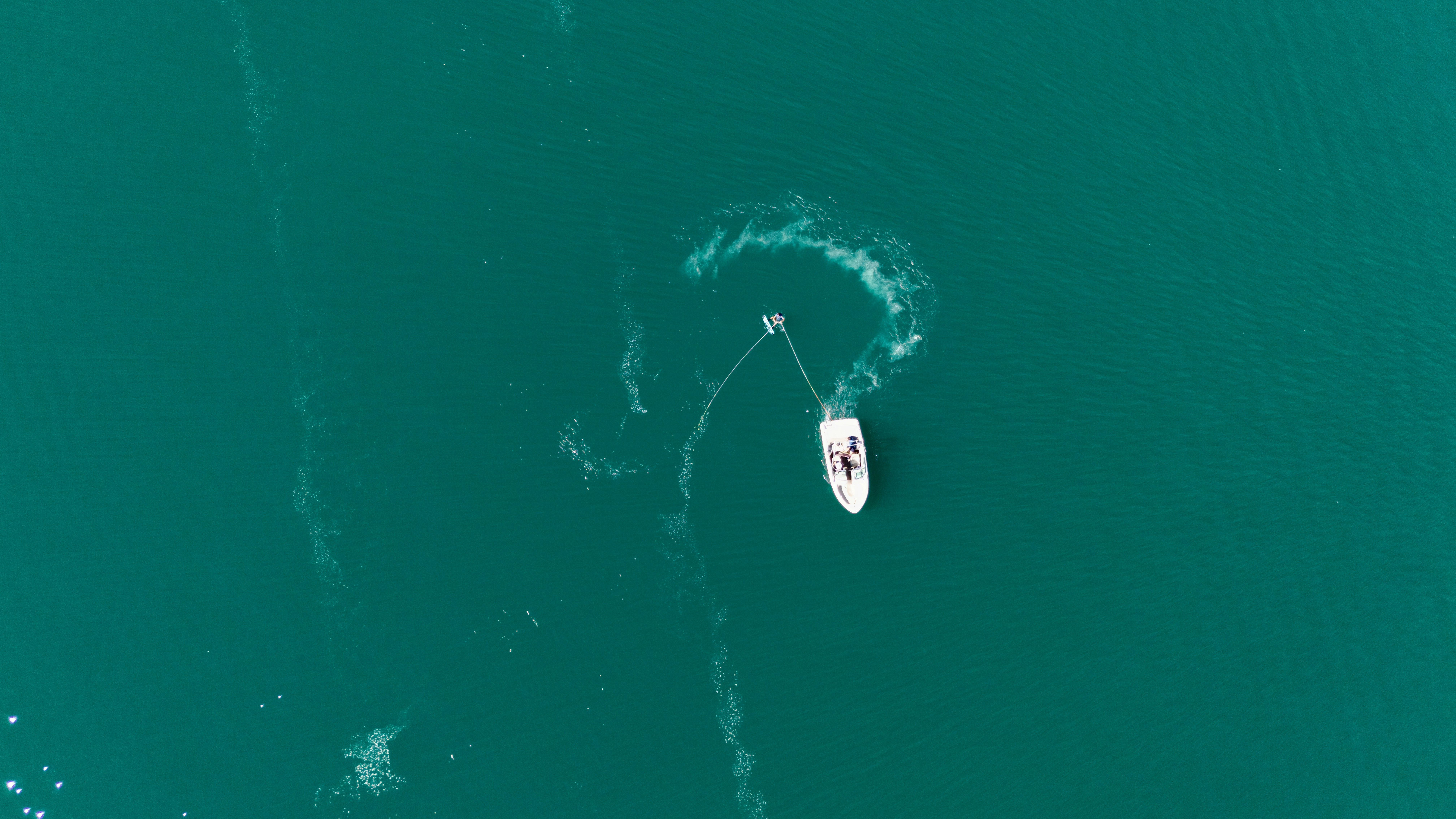 Sailboat making a circular wake on turquoise water