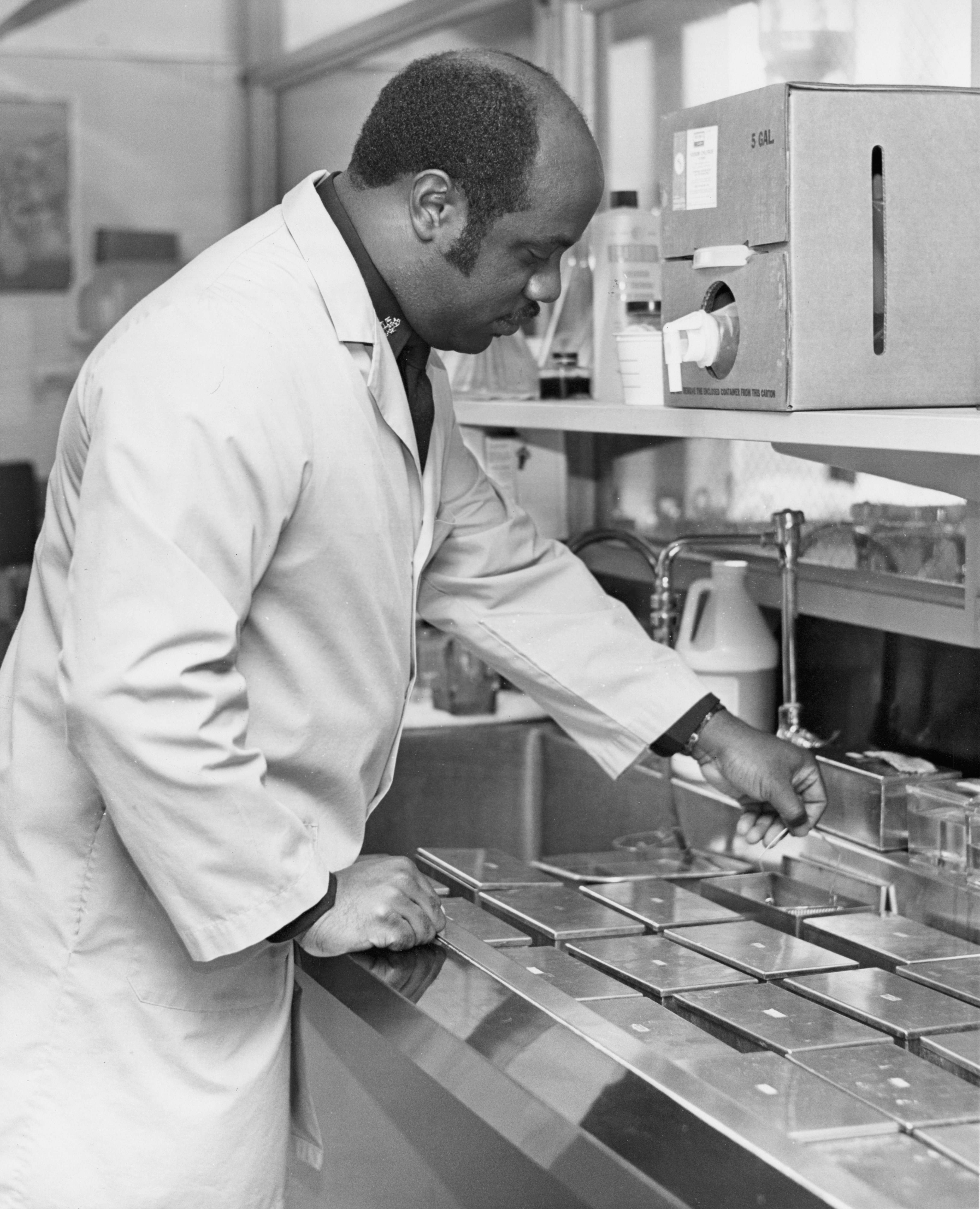 Scientist in lab coat working at a sink