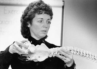 Woman holding a human spine model