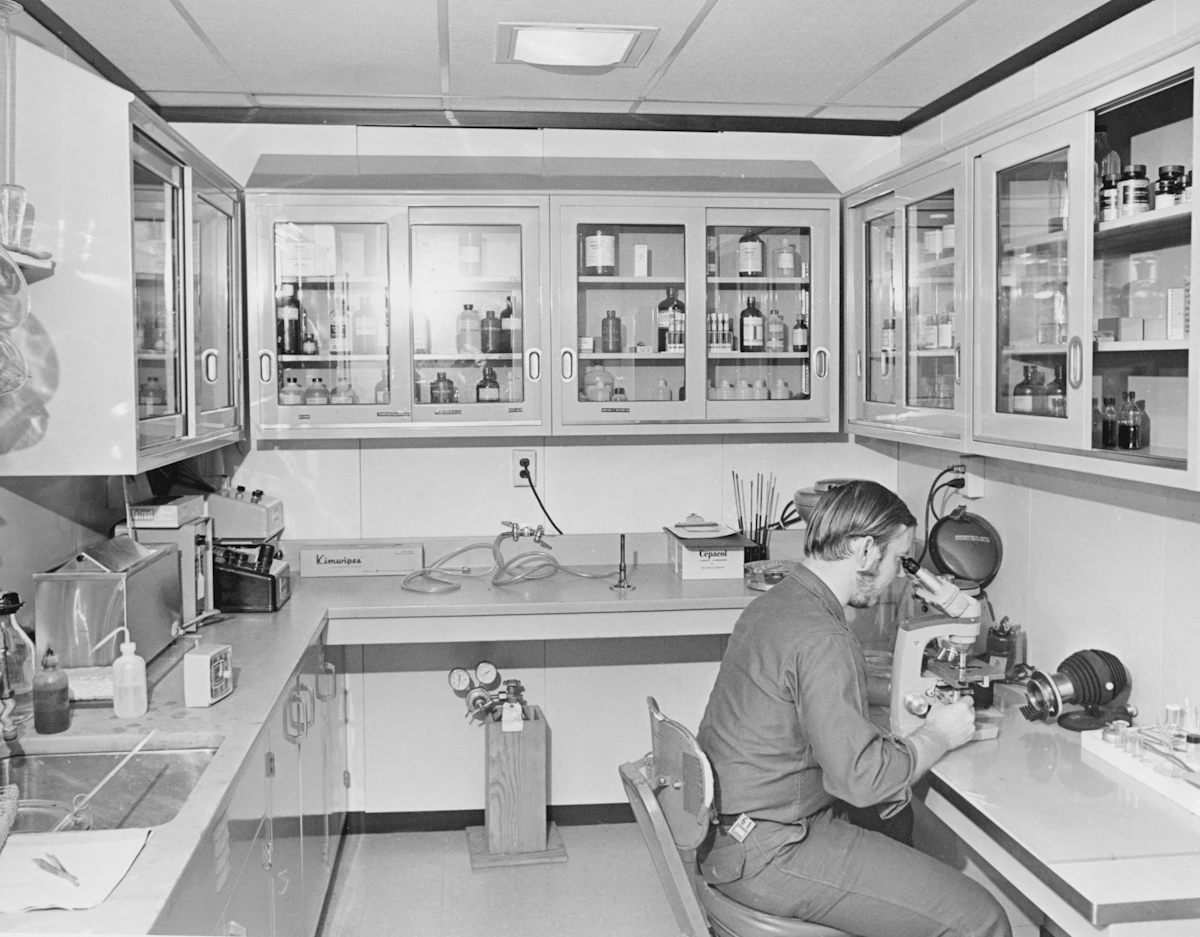 Analista trabajando con un microscopio en el laboratorio