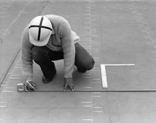 Person marking measurements on a project's construction site