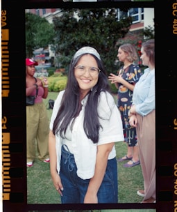 Smiling woman with glasses and friends in background