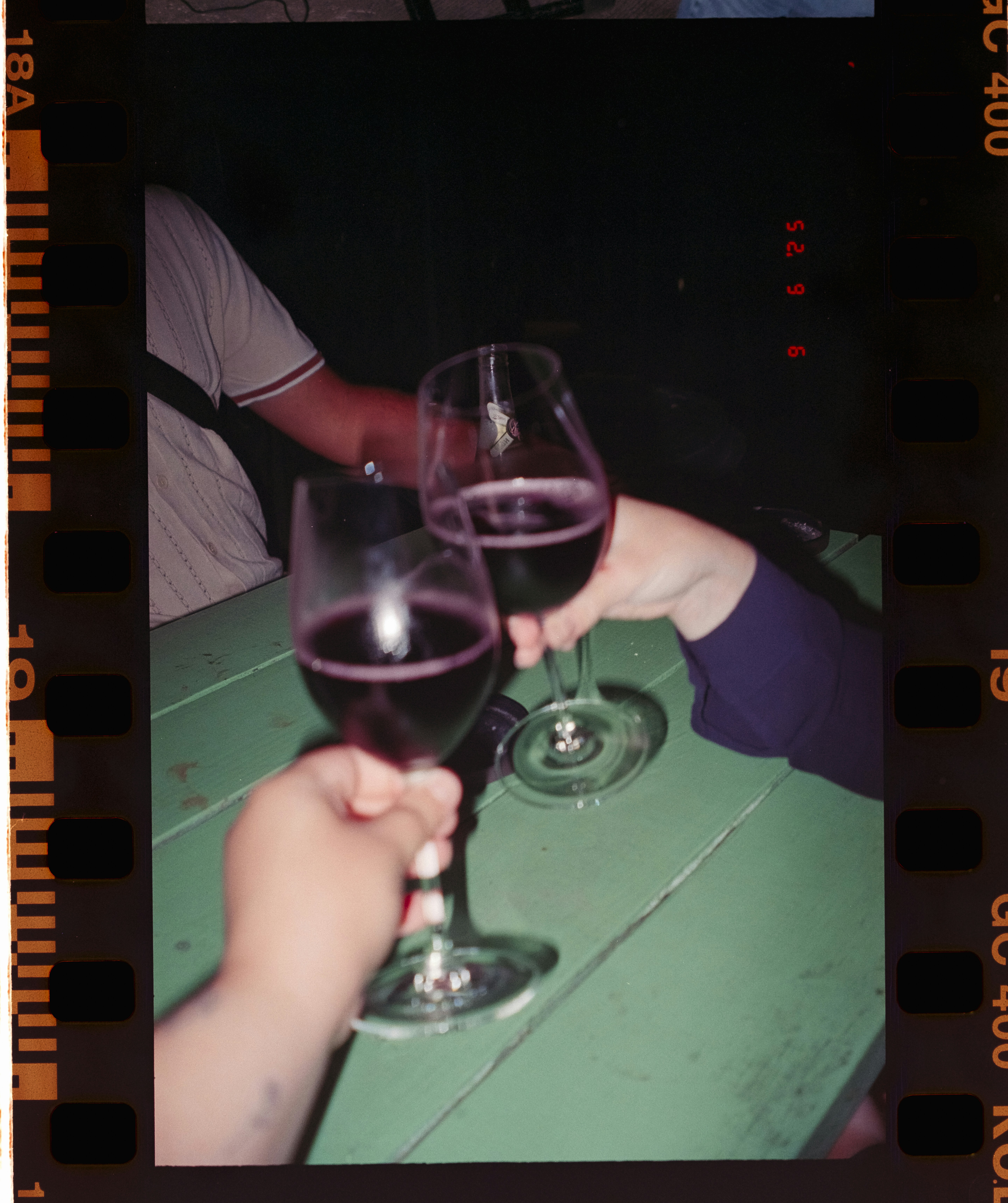 Two glasses of red wine being toasted