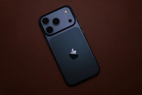 Dark blue smartphone with apple logo on brown surface