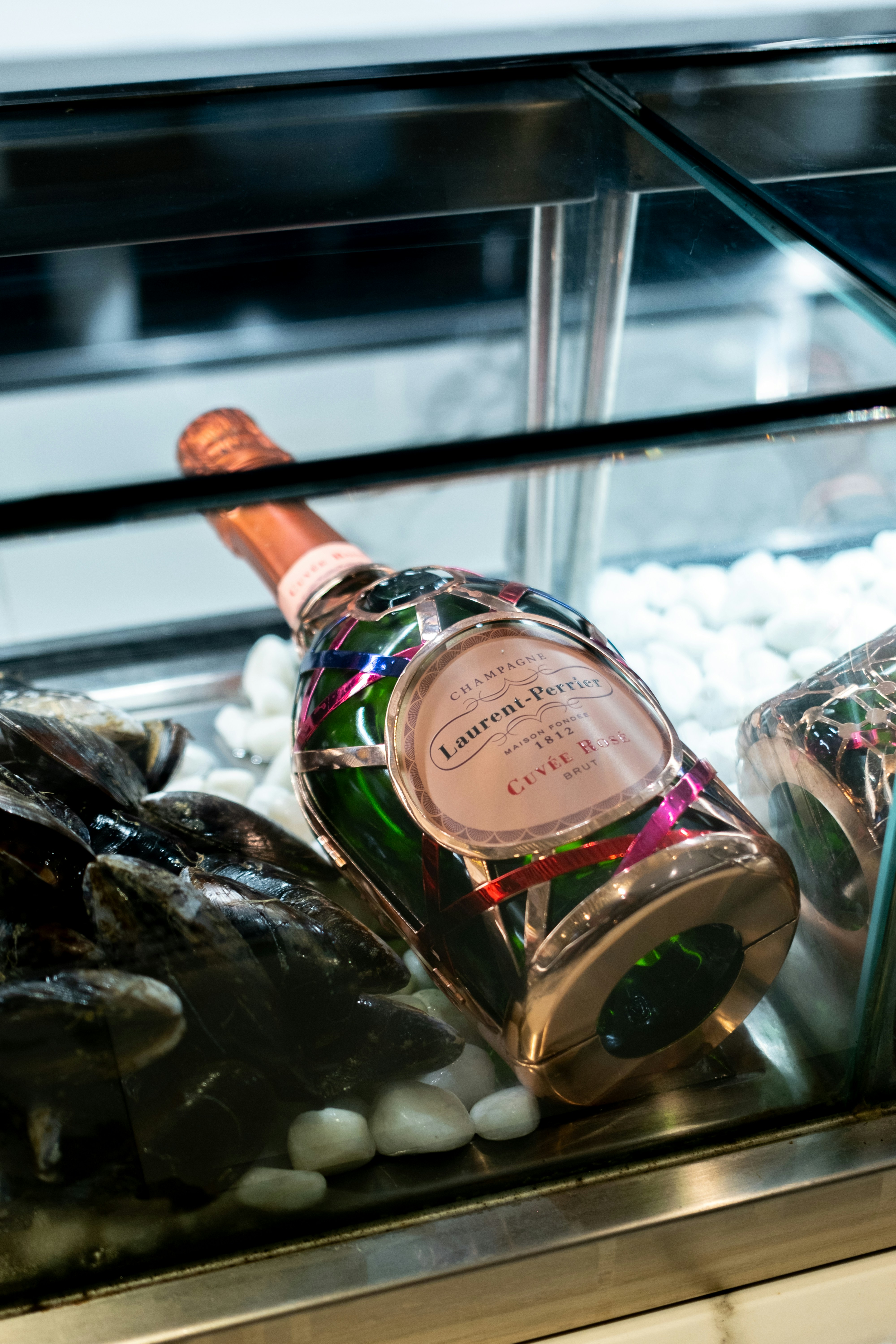 Bottle of champagne resting on white pebbles