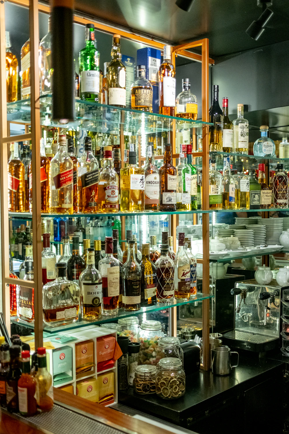 Spritflaskor på hyllor bakom baren