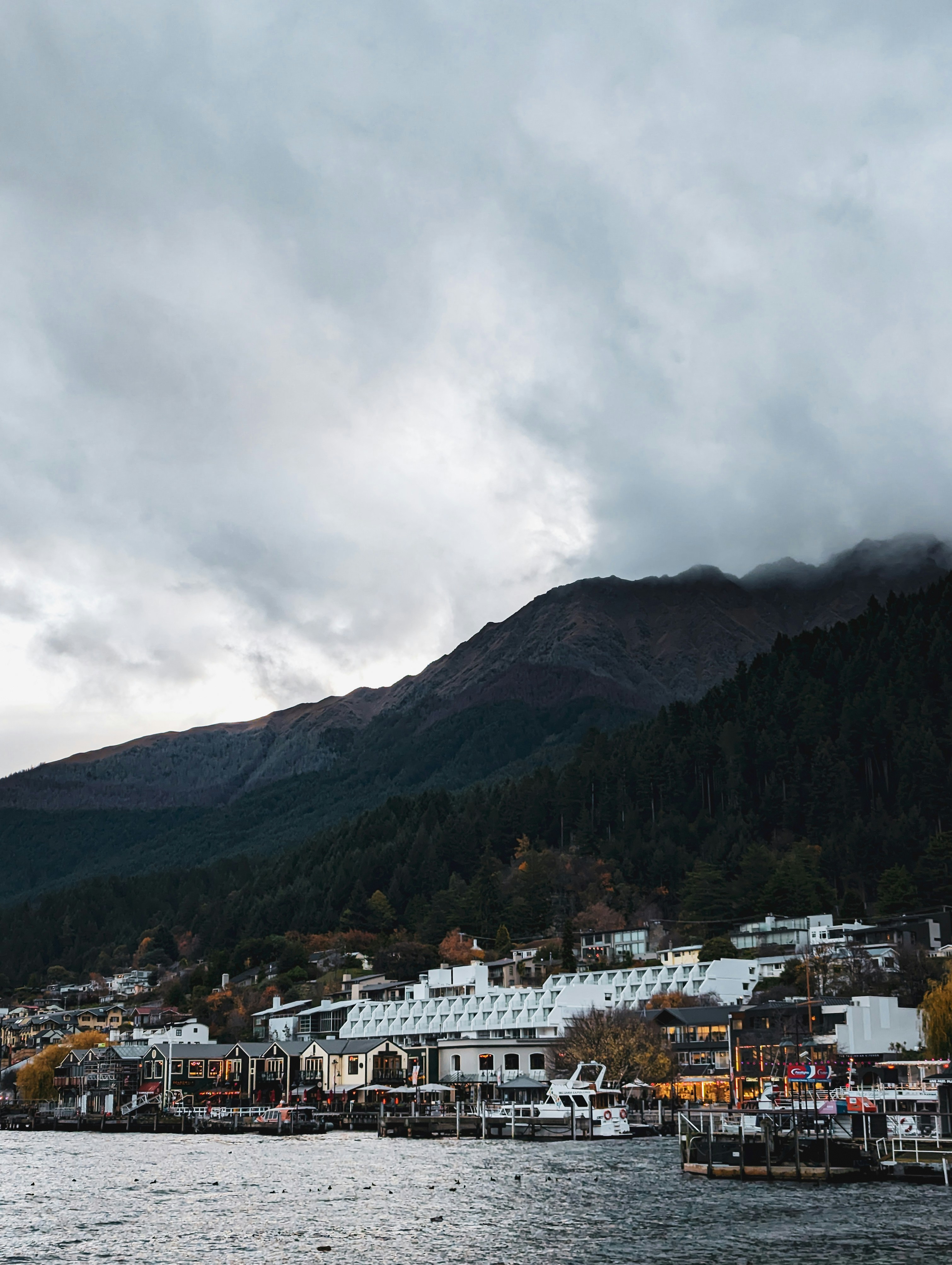 Town nestled by a lake with a mountain backdrop.