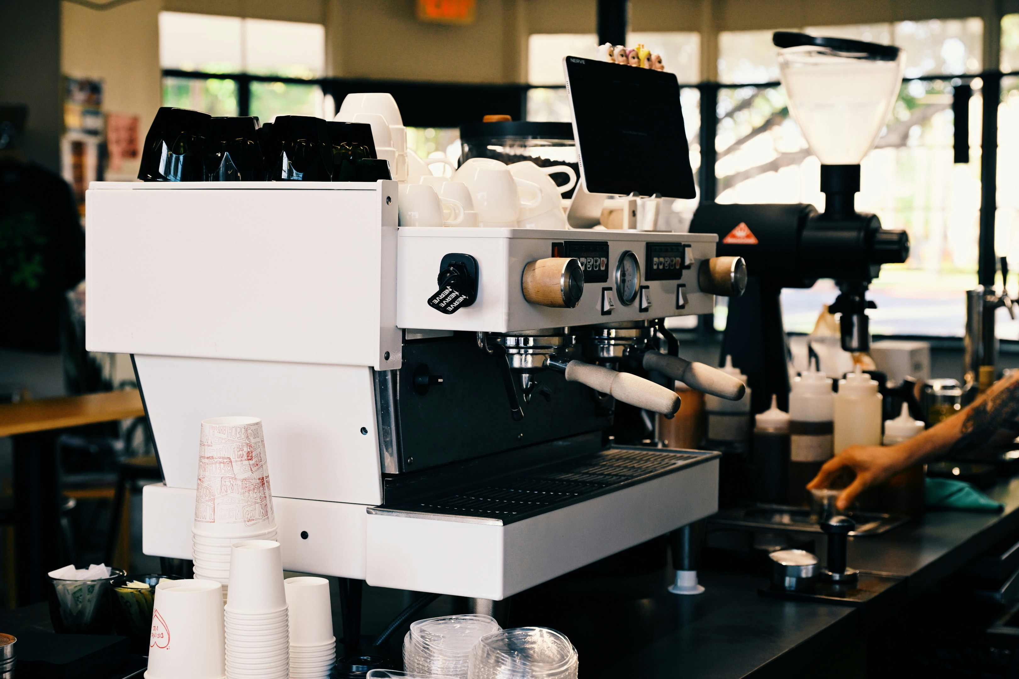 Barista preparing coffee with espresso machine in cafe.
