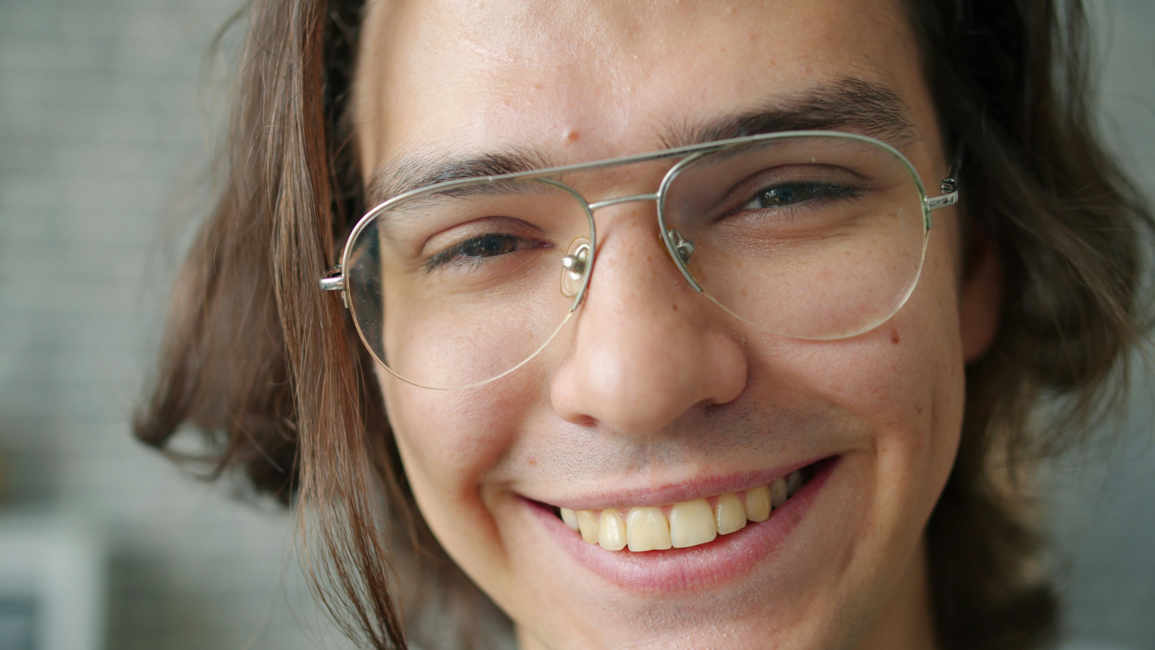 Young man with glasses smiling warmly