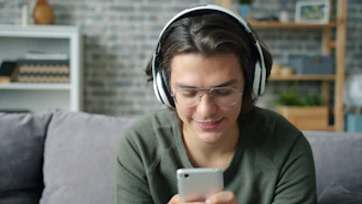 Joven usando auriculares y usando un smartphone tomando terápia psicológica