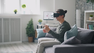 Man wearing vr headset playing video game on couch.
