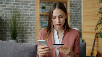 Young woman holding credit card and smartphone