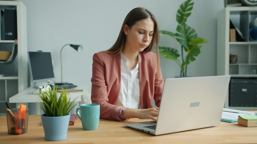 Person sitting alone by a window looking exhausted and staring into the distance