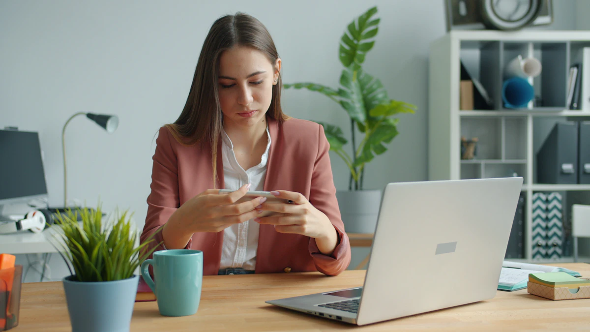 Woman working at a desk with laptop and plants