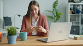 Young woman working at a desk with laptop and laptop