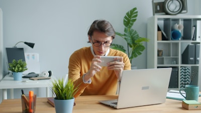 Man playing game on smartphone at desk
