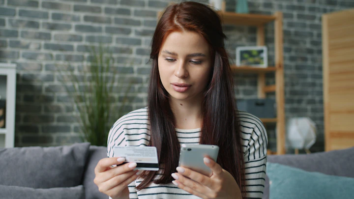 Woman holding credit card and smartphone for online shopping