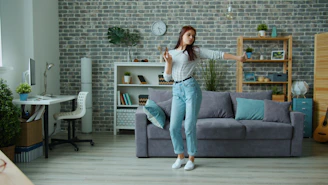 Young woman dancing happily in a modern living room