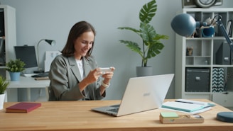 Woman playing a game on her phone at desk.