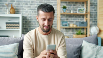 Man sitting on couch using a smartphone