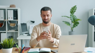 Man smiling while looking at his smartphone at his phone.