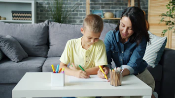 Mother and son drawing together at a table.