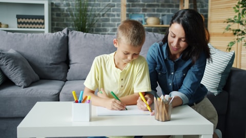Mother and son drawing together at a table.
