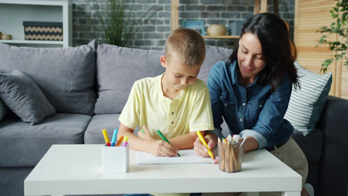 Mother and son drawing together at a table.