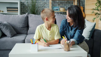 Mother and son drawing at a table together.